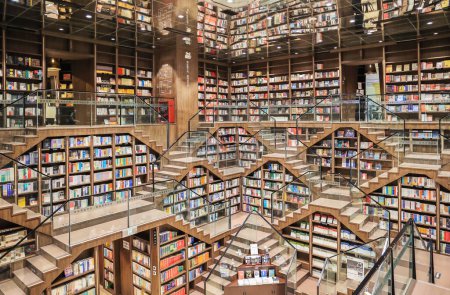 Foto de Chongqing, China - 20 de octubre. 2023: El diseño interior único de la librería Zhongshuge en Chongqing, utilizando escaleras cortas y espejo en el techo para presentar formas geométricas mágicas. - Imagen libre de derechos