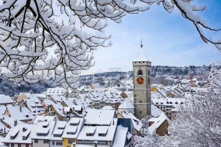 Der Kirchturm von St. Johan über den Dächern der Altstadt nach einem Schneefall im Winter in Schaffhausen, Schweiz