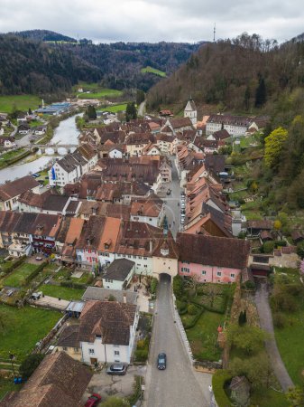 Téléchargez les photos : Vue aérienne de la petite ville médiévale St-Ursanne sur la rivière Doubs sous les montagnes du Jura. Saint-Ursanne a déjà été récompensée comme l'une des plus belles villes de Suisse. - en image libre de droit