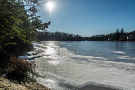 Bright sun on the frozen Mountaintop Lake in Emerald Lakes, the Pocono Mountains of Pennsylvania.