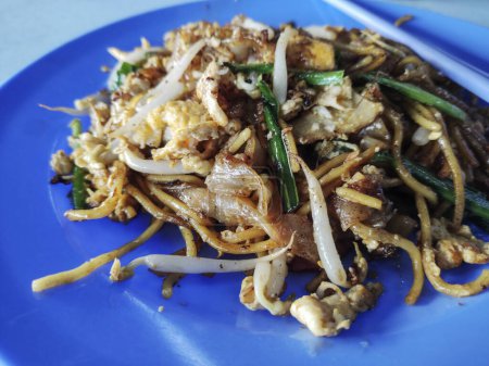 Photo for Penang Char Kway Teow is popular fried noodle with coceral, shrimp and eggs in black sauce in Malaysia - Royalty Free Image