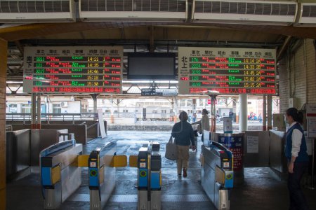Téléchargez les photos : Chiayi, Taiwan- 5 Dec, 2022 : Passager entre dans la porte pour monter à bord du train à la gare de Chiayi. La gare de Chiayi est un bâtiment patrimonial qui accueille toujours des passagers. - en image libre de droit
