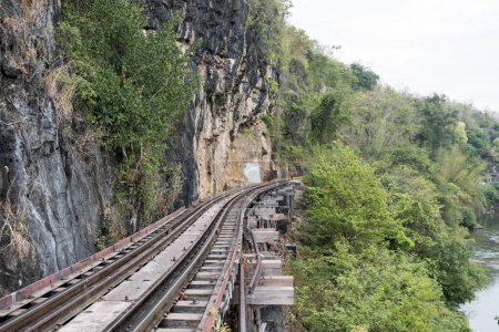 Téléchargez les photos : Kanchanaburi, Thaïlande 16 Feb, 2023 : Les touristes marchent le long du pont ferroviaire Tham Krasae, Kanchanaburi. Il a été construit pendant la Seconde Guerre mondiale de seulement 17 jours au printemps 1943. - en image libre de droit