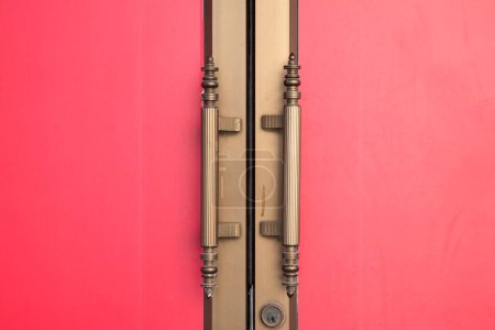 Téléchargez les photos : Poignée de porte en métal sur porte rouge. Condition de fermeture - en image libre de droit