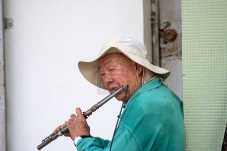 Foto de Johor Bahru, Malasia- 4 Jun, 2023: Artista callejero tocando flauta en Johor Bahru, Malasia. - Imagen libre de derechos