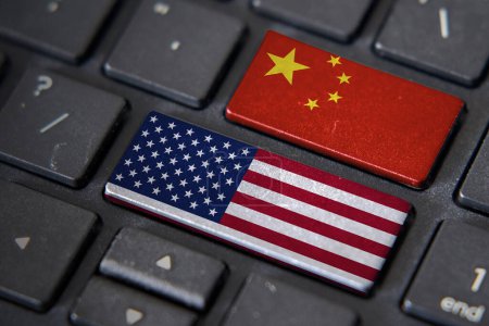 Banderas estadounidenses y chinas en el teclado de la computadora. Relación entre dos países.
