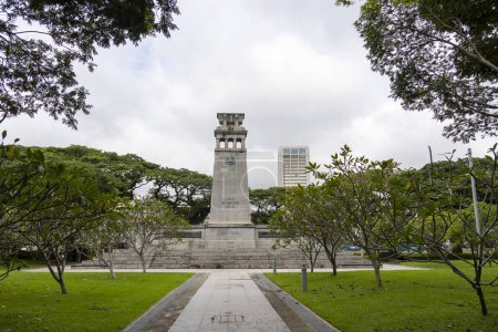 Photo for Singapore-12 Jan, 2024: Gray stone Cenotaph war memorial surrounded by green foliage in Esplanade Park under heavy gray sky promising rain. World War Two side. - Royalty Free Image