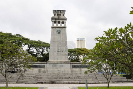 Photo for Singapore-12 Jan, 2024: Gray stone Cenotaph war memorial surrounded by green foliage in Esplanade Park under heavy gray sky promising rain. World War Two side. - Royalty Free Image