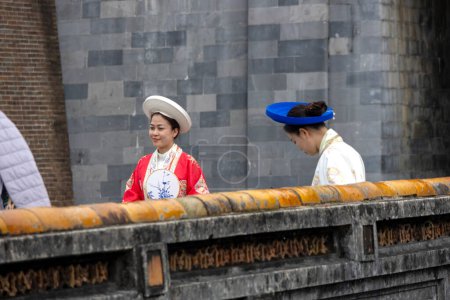 Téléchargez les photos : Hue, Vietnam- 28 Feb, 2024 : Les touristes avec des vêtements traditionnels visitent la ville impériale de Hue, Vietnam. C'est un site du patrimoine mondial de l'UNESCO et une attraction incontournable dans la teinte. - en image libre de droit