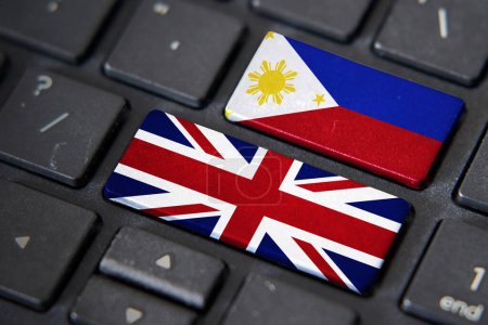 Drapeaux britanniques et philippins sur clavier d'ordinateur. Relations entre deux pays.