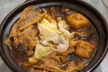 Téléchargez les photos : Bak kut teh servant dans un pot d'argile, un plat de côtes de porc cuit dans un bouillon populairement servi en Malaisie et à Singapour - en image libre de droit