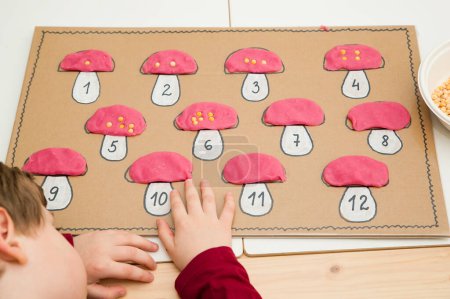 Photo for Kid learns to count. Logical tasks for the preschool class. Child employment, fine motor skils training, learning to keep focus, task completion, children motivation. DIY Montessori activities. - Royalty Free Image