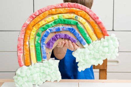 Kid at home makes and paints a rainbow. Exercise for Young artist. Early education, Montessori methodology. Implement to develop fine motoric skills. Zero waste, DIY games at home.