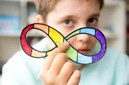 Photo for Autism infinity rainbow symbol sign in kid hand. World autism awareness day, autism rights movement, neurodiversity, autistic acceptance movement - Royalty Free Image