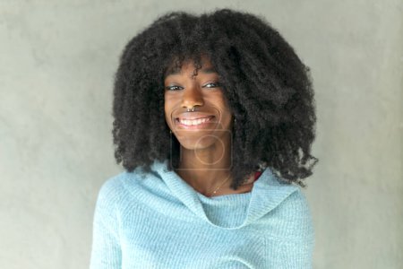 portrait happy young black woman laughing against wall