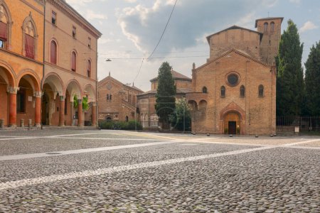 Piazza Santo Stefano. Vista de la fachada de la basílica y la gente caminando o de pie en la plaza. Ambiente italiano de verano