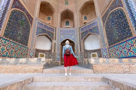 Rückansicht einer jungen Frau in Buchara, Usbekistan Mir-i-Arab Madrasa Kalyan Minarett und Turm. Übersetzung über Moschee: "Poi Kalyan Moschee"