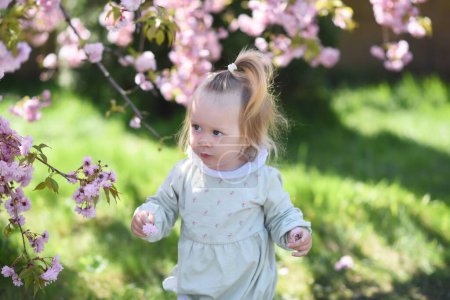 Photo for Girl in the park with flowers. little girl in the garden - Royalty Free Image