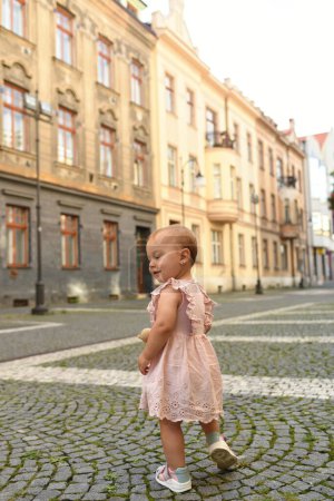 Téléchargez les photos : Petite fille dans la rue de la belle vieille ville - en image libre de droit
