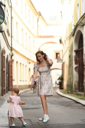 Photo for Woman with kid in the street of beautiful old town - Royalty Free Image