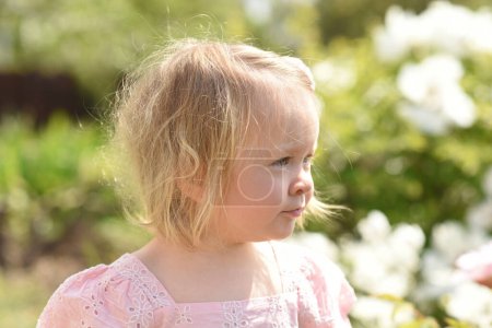 Foto de Un niño pequeño en el parque. niña en un campo de flores - Imagen libre de derechos