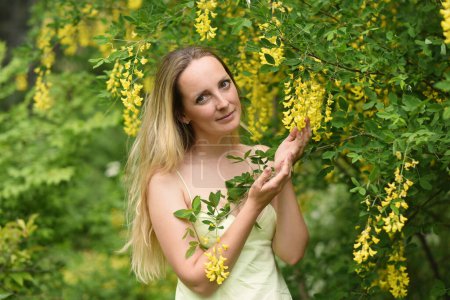 Foto de Mujer con flores amarillas en el parque - Imagen libre de derechos