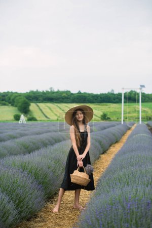 Photo for Beautiful girl with long hair in a lavender field. Beautiful girl in a hat. Summer in the lavender field - Royalty Free Image