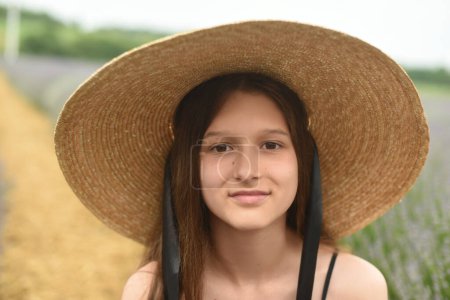 Foto de Retrato de una mujer con sombrero. Hermosa chica con el pelo largo sonriendo. chica en el campo de lavanda - Imagen libre de derechos