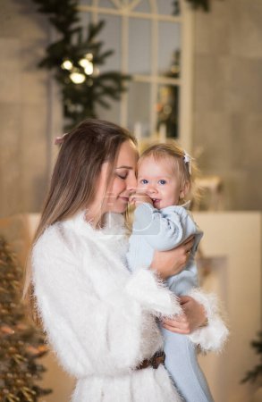 Téléchargez les photos : Mère et fille souriant et jouant près du sapin de Noël - en image libre de droit