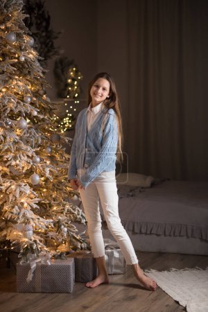 Photo for Beautiful young girl with long hair near the Christmas tree. Christmas holidays at home - Royalty Free Image
