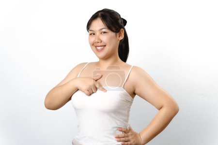Asian woman checking lumps on her breast for signs of breast cancer on white background. Healthcare and medical concept.