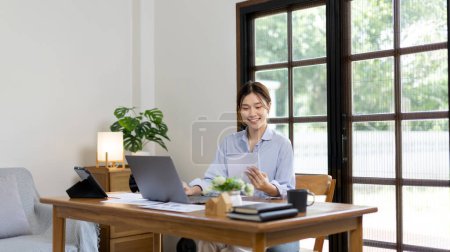 Foto de Work from home, College student is analyzing data or doing homework assignments in her house, Use your laptop to search for information and educate yourself at home, Stay home, Internet learning. - Imagen libre de derechos