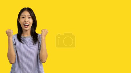 Photo for Asian woman posing extremely happy to win, Successful, Show extreme happiness, Very happy, yes, Lonely woman on yellow background. - Royalty Free Image