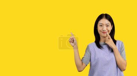 Photo for Asian woman pointing finger inviting click here, It is recommended to follow this direction or click on this link, Space for promotion here, Register or apply for membership, Click here. - Royalty Free Image