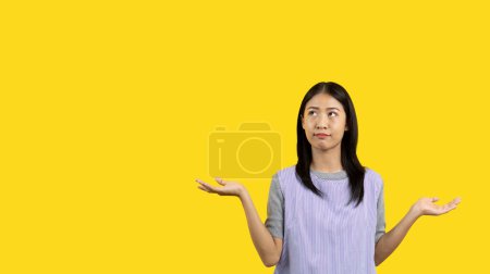 Foto de Woman doing boring poses on colored background,  Acting indifferently, Indifferent to what is going on, Acting not concerned, Yellow background, Ignorant, Up to you. - Imagen libre de derechos