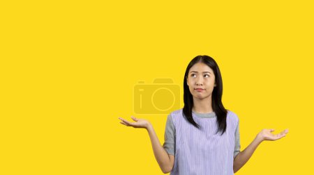 Photo for Woman doing boring poses on colored background,  Acting indifferently, Indifferent to what is going on, Acting not concerned, Yellow background, Ignorant, Up to you. - Royalty Free Image
