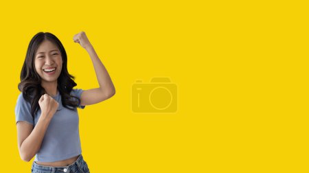 Photo for Asian woman posing extremely happy to win, Successful, Show extreme happiness, Very happy, yes, Lonely woman on yellow background. - Royalty Free Image