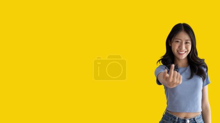 Photo for Women beckoning or inviting them to pay attention, Suggest to click or apply with me, Giving assistance and acceptance, Calling with one finger, Come and get me, Woman on yellow background. - Royalty Free Image