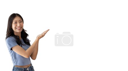 Téléchargez les photos : Femme asiatique avec tenant copyspace imaginaire sur la paume pour insérer une annonce, Montrant copyspace pointant, Montrant sa main pour présenter quelque chose sur fond blanc. - en image libre de droit