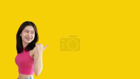Photo for Asian woman pointing finger inviting click here, It is recommended to follow this direction or click on this link, Space for promotion here, Register or apply for membership, Click here. - Royalty Free Image