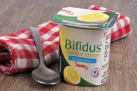 Téléchargez les photos : Yogourt bifidus à la saveur de citron de marque Netto avec cuillère et serviette close up - en image libre de droit