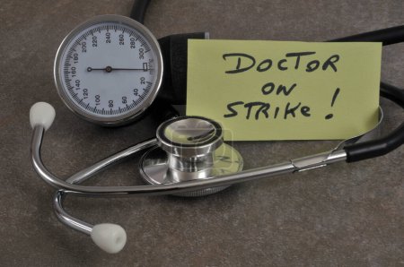 Téléchargez les photos : Doctor on strike written on a paper surrounded by medical instruments - en image libre de droit