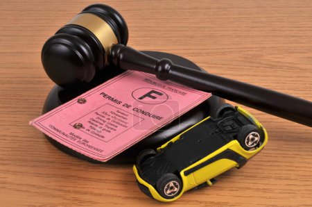 Photo for French driving license withdrawal concept with judge gavel and overturned toy car - Royalty Free Image
