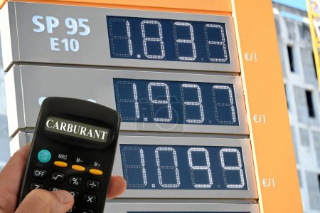 Treibstoffpreise an einer Tankstelle in Frankreich, im Vordergrund ein Taschenrechner