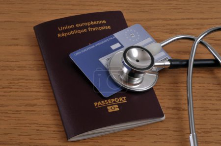Photo for European health insurance card and stethoscope lying on a European Union passport on a wooden background - Royalty Free Image