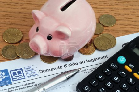 Foto de Francés Formulario de solicitud de ayuda para la vivienda con una alcancía y una calculadora - Imagen libre de derechos