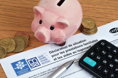Foto de Francés Formulario de solicitud de ayuda para la vivienda con una alcancía y una calculadora - Imagen libre de derechos