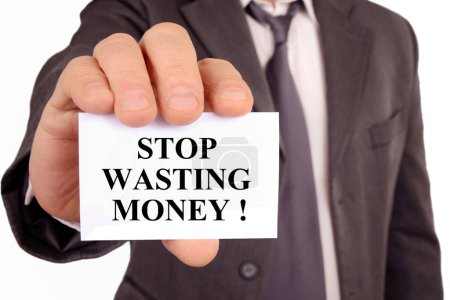 Photo for Businessman holding a card with stop wasting money written on it - Royalty Free Image