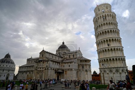 Photo for Tourists in front of the Leaning Tower of Pisa in Tuscany with cloudy sky - Royalty Free Image
