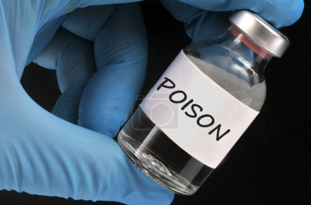 Téléchargez les photos : Concept de bouteille de poison tenue par la main gantée gros plan sur fond noir - en image libre de droit